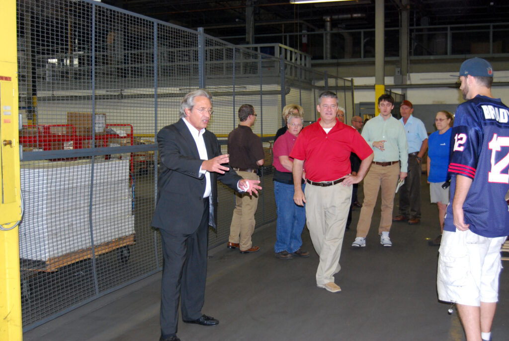 Man in warehouse talking to group of people